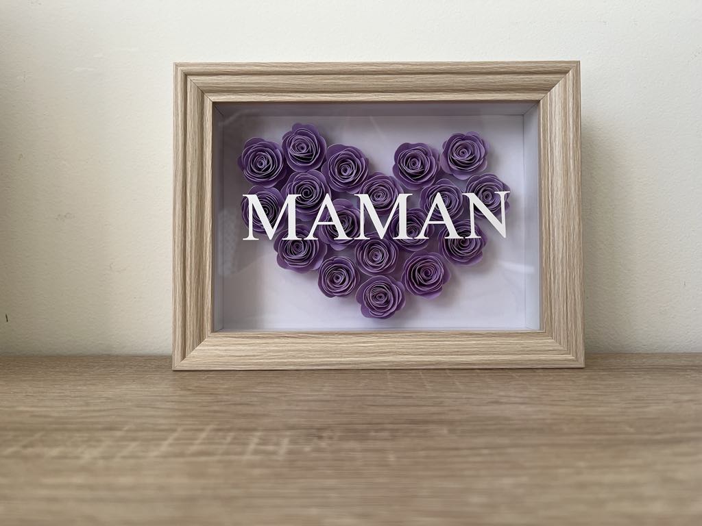 Cadre en bois, coeur réalisé en fleurs en papier à la main violettes, mot Maman inscrit sur la vitre du cadre